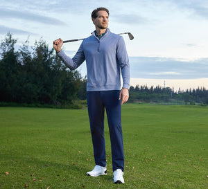 The model wears a Quarter Zip Melange Pullover and Stretch Plain Everyday Pants, carrying a golf club over her shoulder.