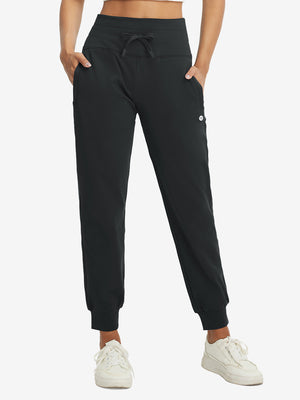 Model wearing women's stretch fleece lined water resistant joggers in black, showcasing the front lower body view.
