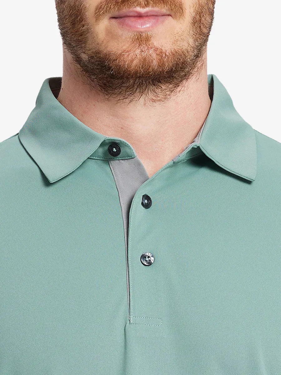 Model wearing the beryl green long sleeve pique polo, showcasing its sleek design and comfort.