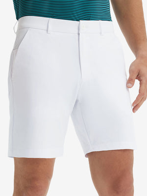 Front lower body shot of model wearing the white stretch soft flat front dress golf shorts, showcasing the fit