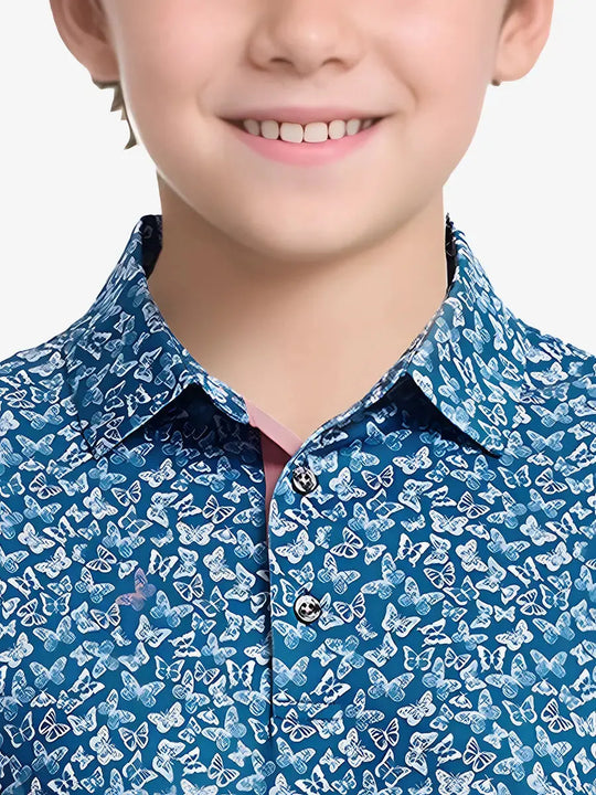 Front view from nose to chest of boy in BLUE WHITE BUTTERFLY golf polo on sunny course