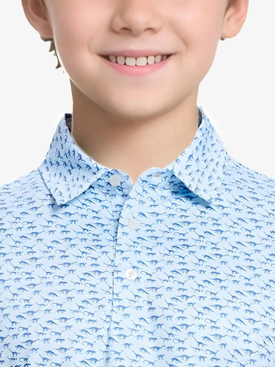 Close-up front view from nose to chest of boy wearing BLUE DINOSAUR Performance Print Boys Golf Polo