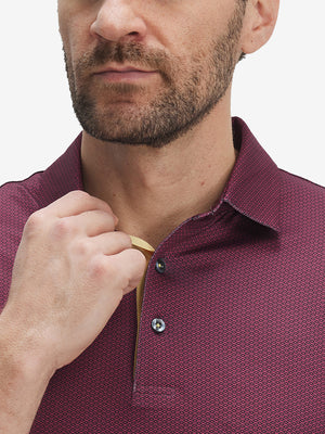 Front view from nose to chest of model wearing the burgundy geometric 4 way stretch print collared polo shirt, showcasing the upper fit
