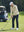 Model in light khaki softshell water resistant lightweight jacket preparing to tee off, full-body shot