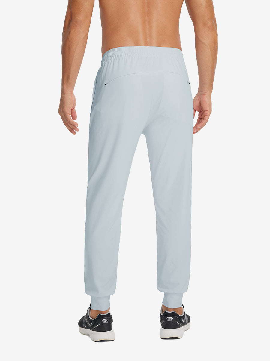 Back lower-body view showing lightweight traning track pants on model in misty grey.