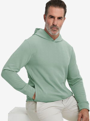 Model front upper body, one hand in pocket, wearing texture solid hoodies pullover, beryl green.