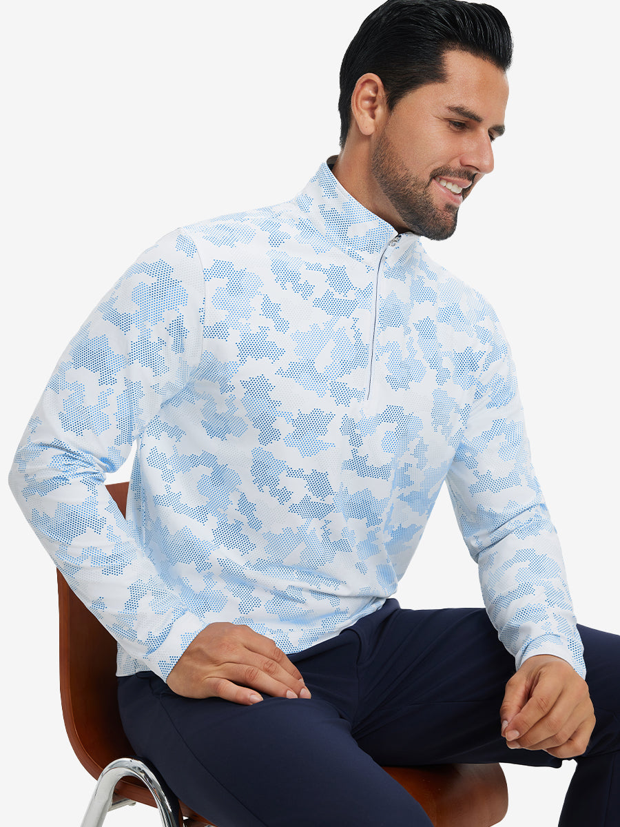 Model seated on chair, wearing full print quarter zip pullover in sky blue camo, casual upper body view.