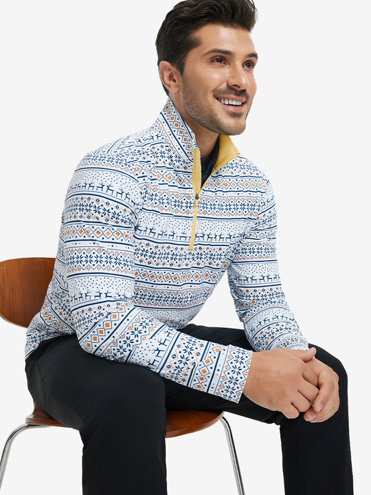 Model seated on chair, wearing full print quarter zip pullover in christmas snowflake, casual upper body view.