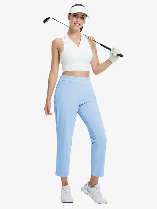 Full-body front view wearing golf hat and holding club in LIGHT BLUE Women's 7/8 Ankle Golf Track Pants.