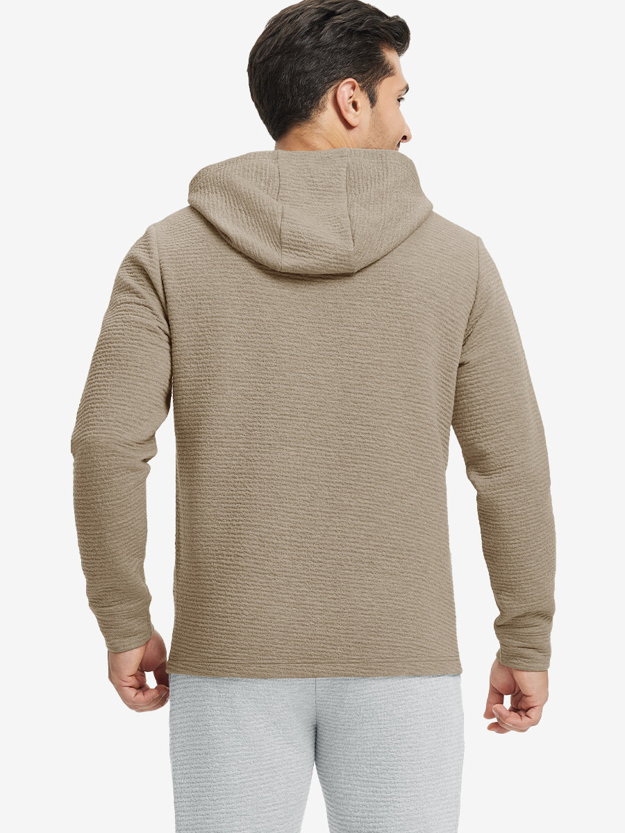 Back view of model wearing texture solid hoodies pullover showing fit and hood detail, light brown heather.