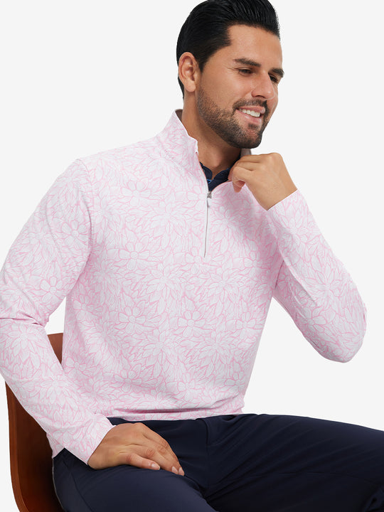 Model seated on chair, wearing full print quarter zip pullover in pink artichoke, casual upper body view.
