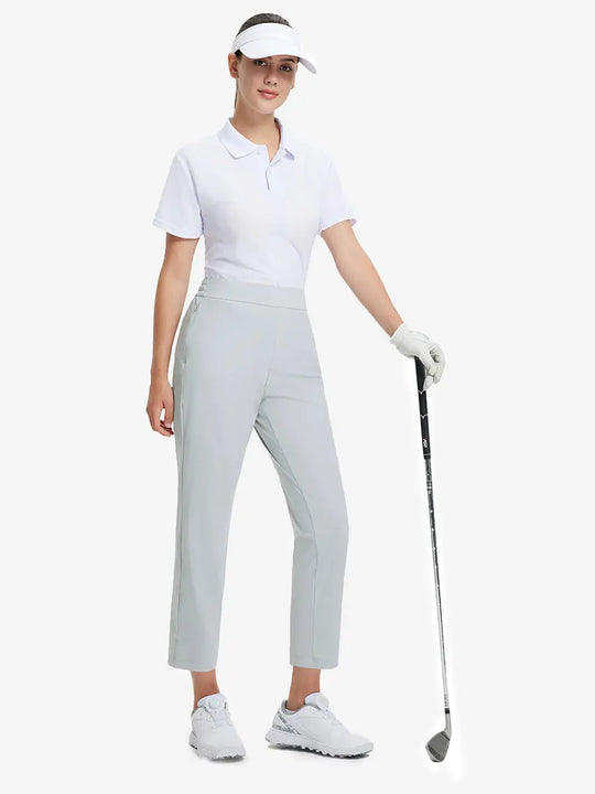Full-body front view wearing golf hat and holding club in GLACIER GREY Women's 7/8 Ankle Golf Track Pants.