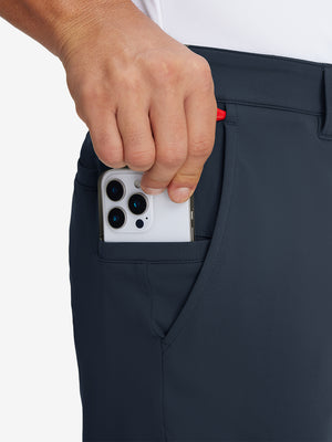 Hand placing an iPhone into pocket of soft lightweight casual golf pants with 5 pockets in navy.