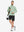 Full-body view of model carrying golf bag in quarter zip melange pullover beryl green melange.