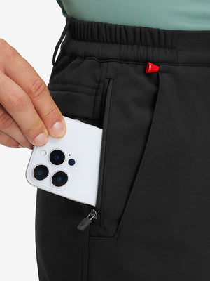 Close-up detail showing phone being placed in the pocket of black thermal water repellent fleece dress pants