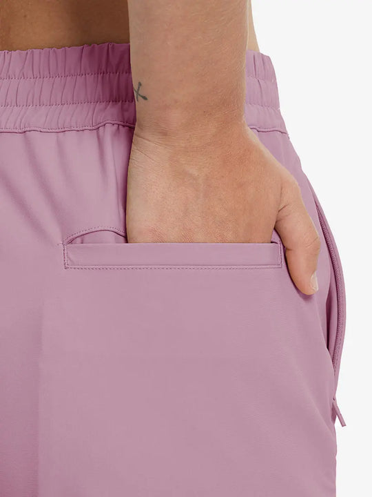 Back view with hand in rear pocket wearing PINK Women's 7/8 Ankle Golf Track Pants.