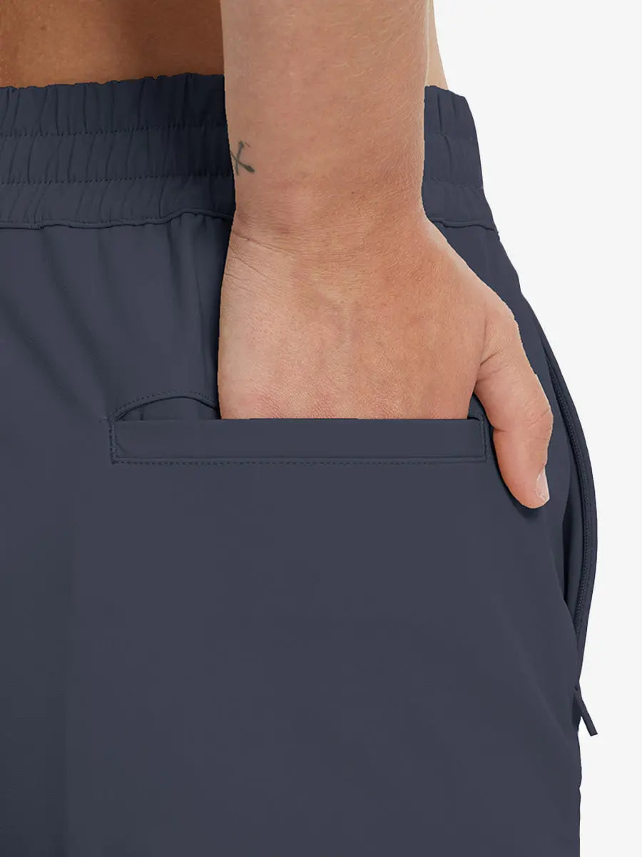 Back view with hand in rear pocket wearing NAVY Women's 7/8 Ankle Golf Track Pants.