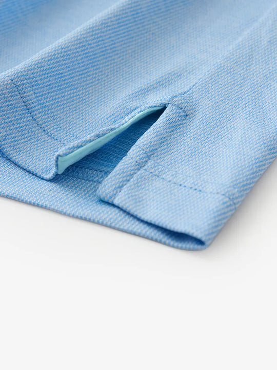 Hem slit detail of BLUE HEATHER Premium Stretch Heather Polo highlighting stitching and finish.