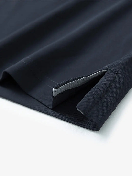 Detail view of the dark grey long sleeve pique polo, highlighting the hem opening and modern design