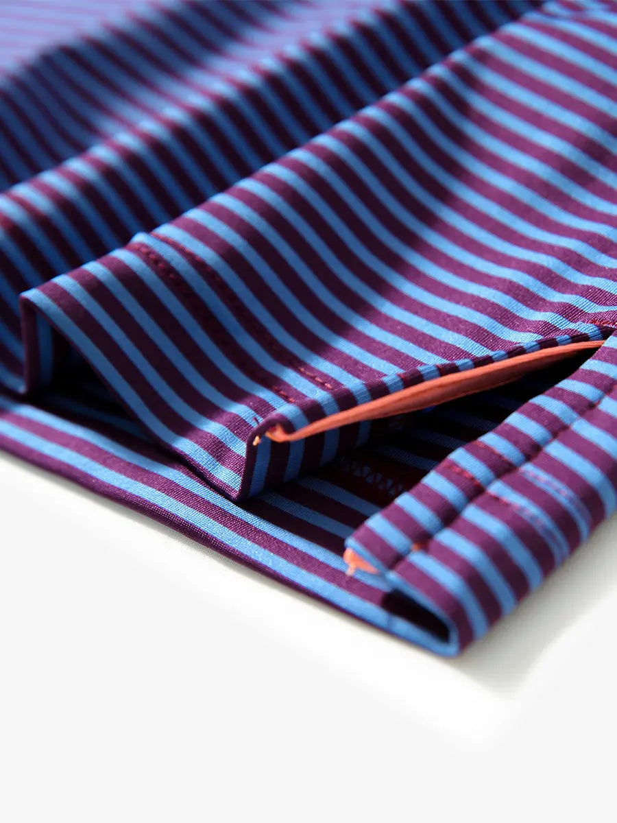 Close-up of side hem slit on PLUM BLUE STRIPE polo, detailing for comfort and mobility