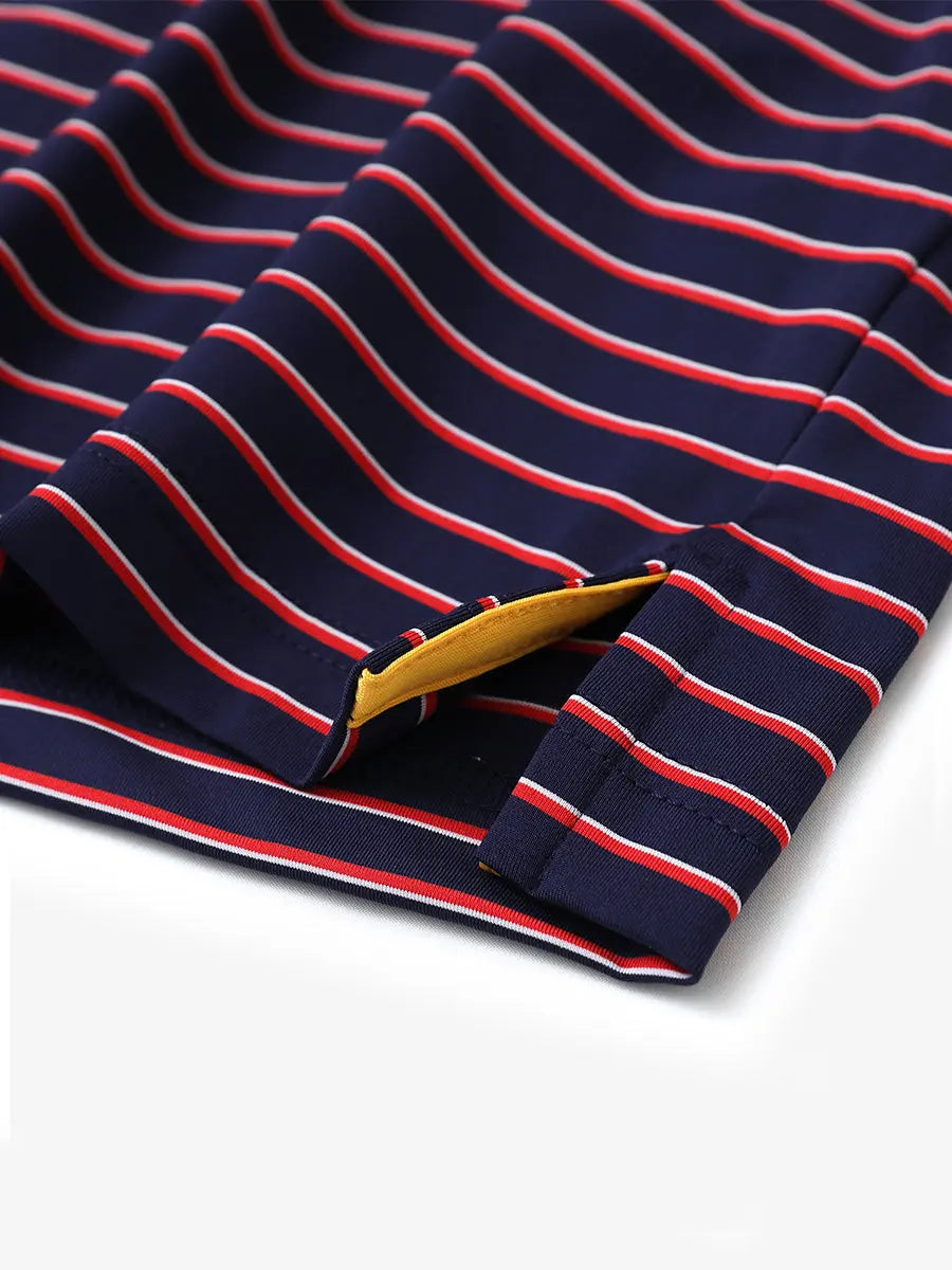 Hem slit detail of NAVY/RED STRIPE Youth Performance Golf Polo highlighting stitching and finish.