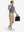Full-body shot of model holding a briefcase in misty blue white grid ultra-light quick dry moisture wicking collared polo shirt