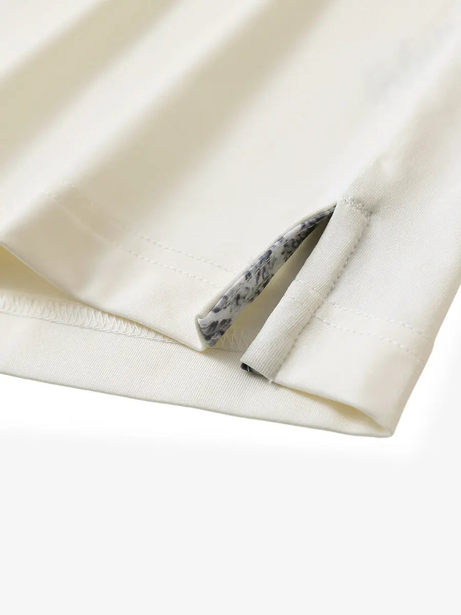 Close-up of side slit hem detail on CREAM Long Sleeve Solid Jersey Polo
