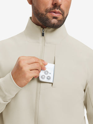 Close detail of hand in chest pocket of water-resistant zip up golf jacket in light khaki.