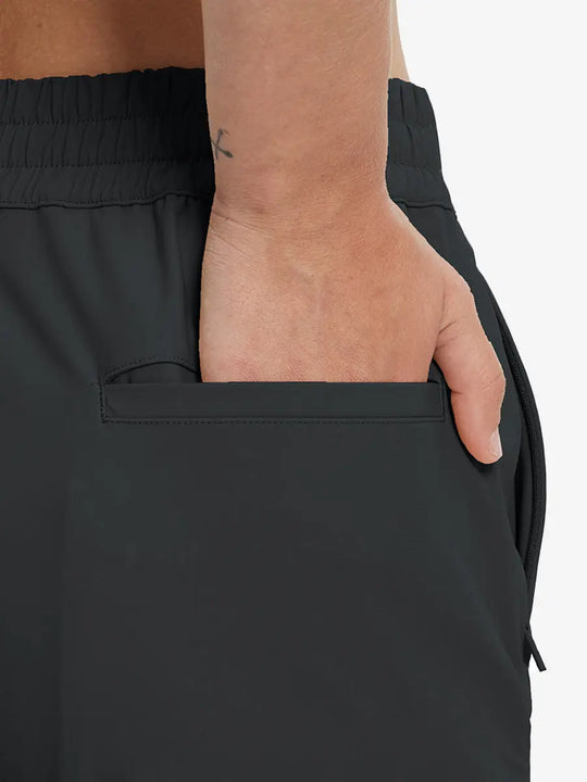 Back view with hand in rear pocket wearing BLACK Women's 7/8 Ankle Golf Track Pants.