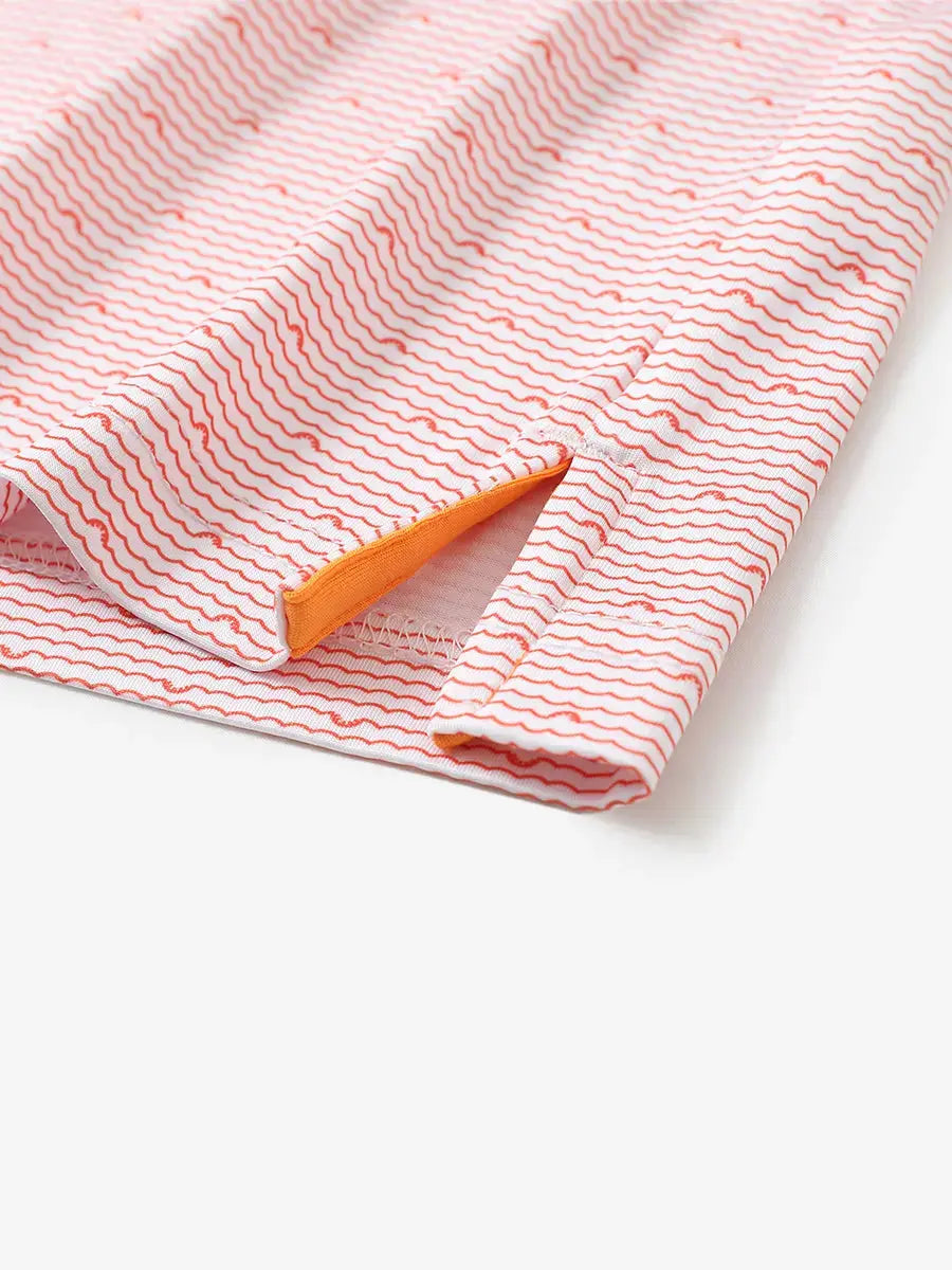 Detailed close-up of side hem slit on ORANGE SEA WAVE Performance Print Boys Golf Polo for comfort