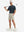 Full-body shot of model holding a golf club in navy coconut tree breathable jacquard pattern 3-button golf polo