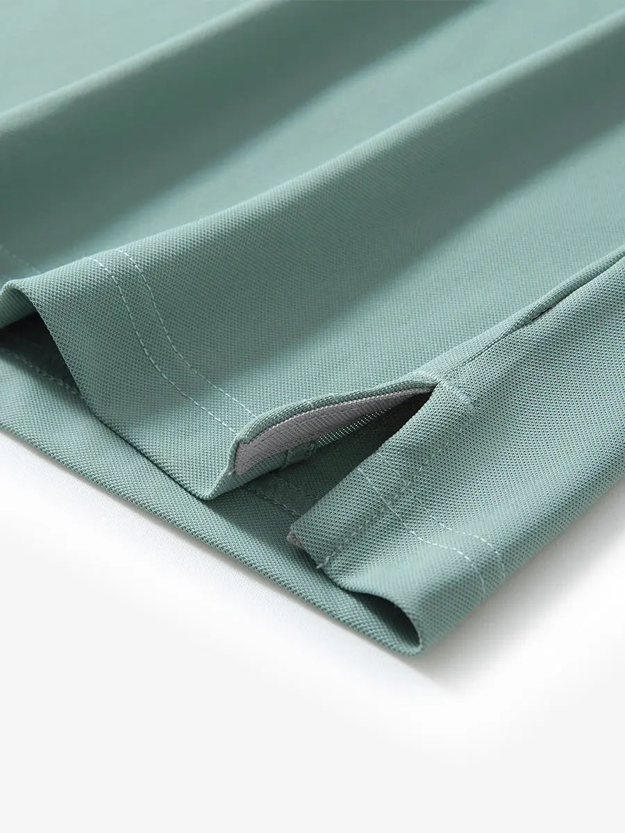 Detail view of the beryl green long sleeve pique polo, focusing on the hem opening and sleek design.