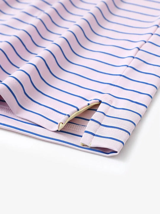 Hem slit detail of LIGHT PINK/COBALT STRIPE Youth Performance Golf Polo highlighting stitching and finish.