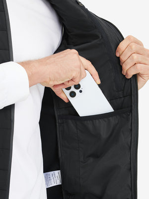 Inner pocket detail of Lightweight Water Resistant Puffer Vest in black, holding smartphone