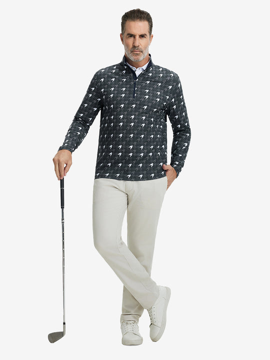Full-body shot of model holding golf club, dressed in full print quarter zip pullover in grey houndstooth.