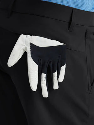 Back view of Player Fit Versatile Solid Shorts with golf glove tucked into right pocket – BLACK