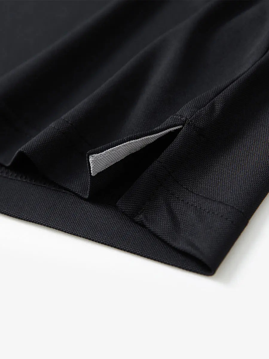 Detail view of the black long sleeve pique polo, showcasing the hem opening and refined design.