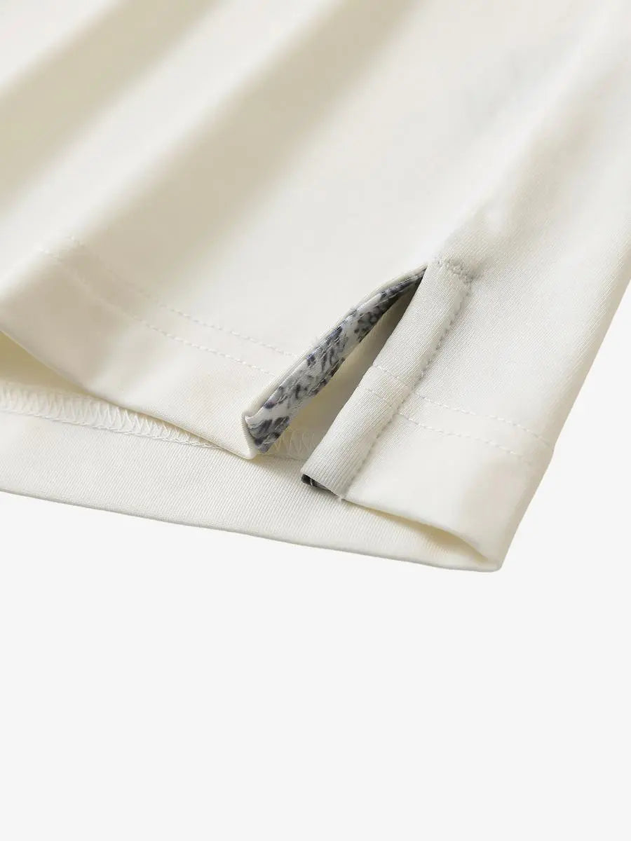 Close-up of side slit detail on the Cream Everyday Classic Solid Polo hem