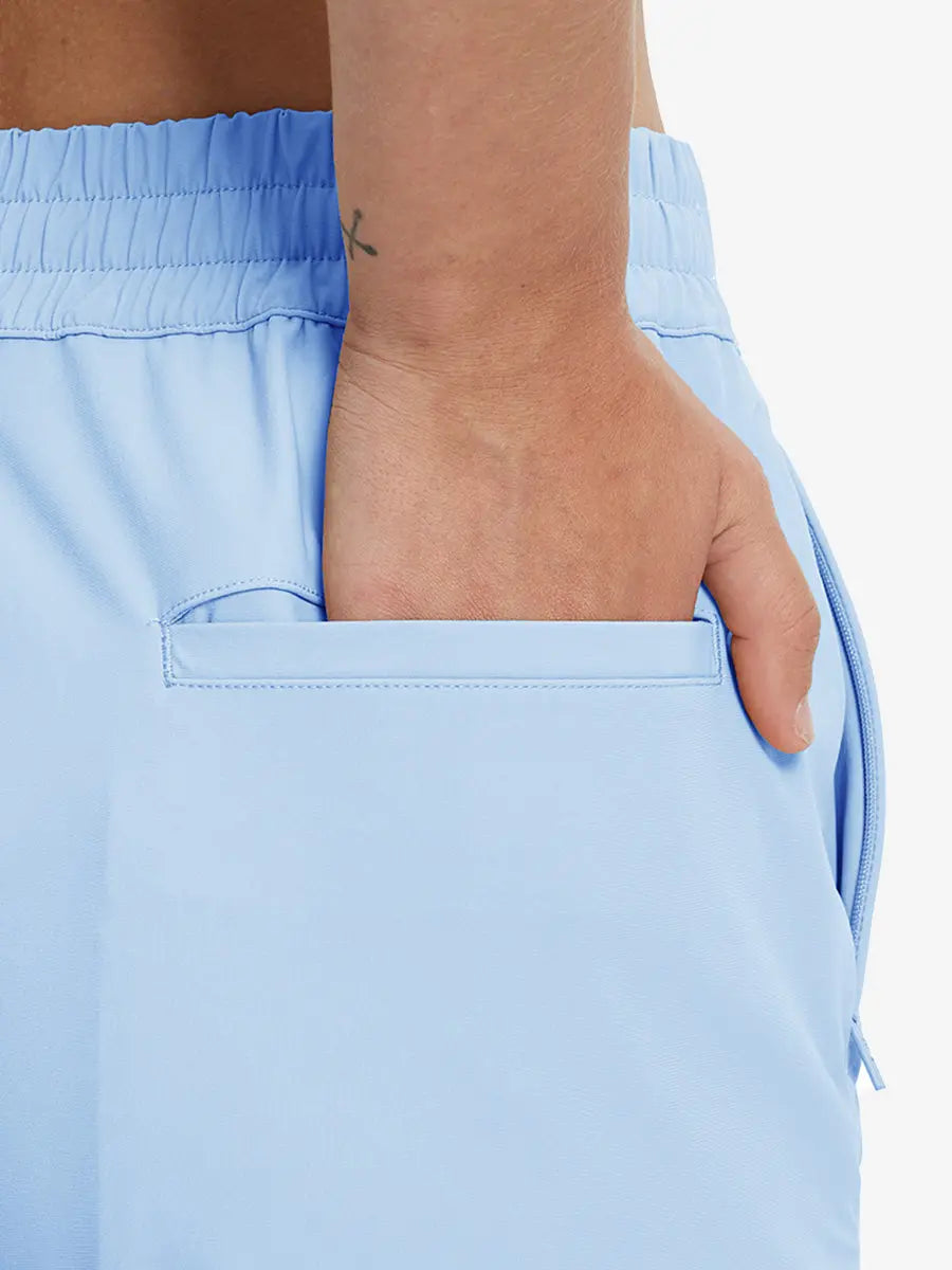 Back view with hand in rear pocket wearing LIGHT BLUE Women's 7/8 Ankle Golf Track Pants.