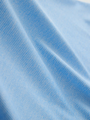 Fabric close-up of Premium Stretch Heather Polo showing crisp stripes and blue heather detail