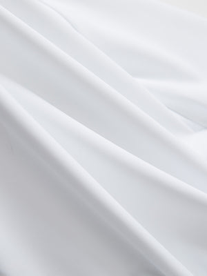 Close-up texture of white breathable casual slacks with 4 pockets fabric showing detailed breathable material and weave.