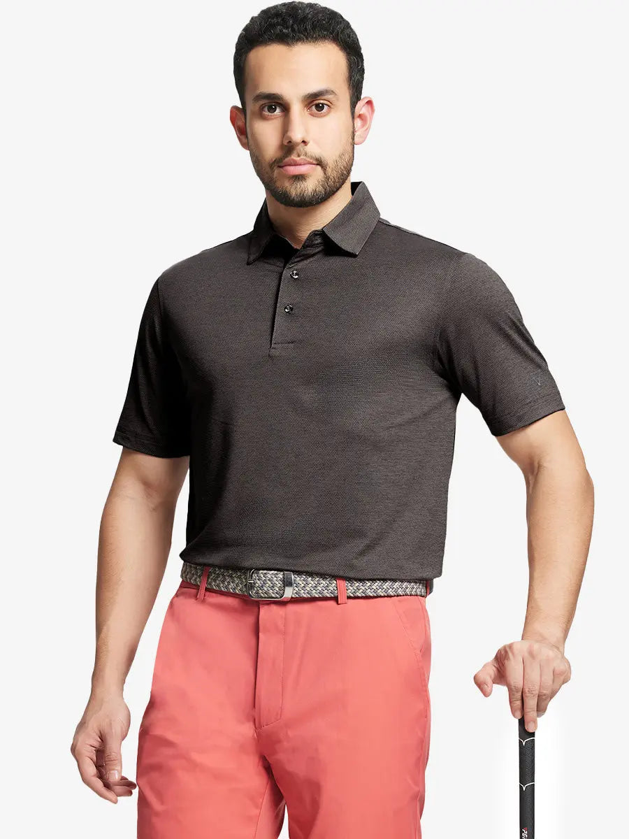 Front half-body shot of model holding golf club wearing Ventilated Heather Jacquard Polo – DARK BROWN HEATHER