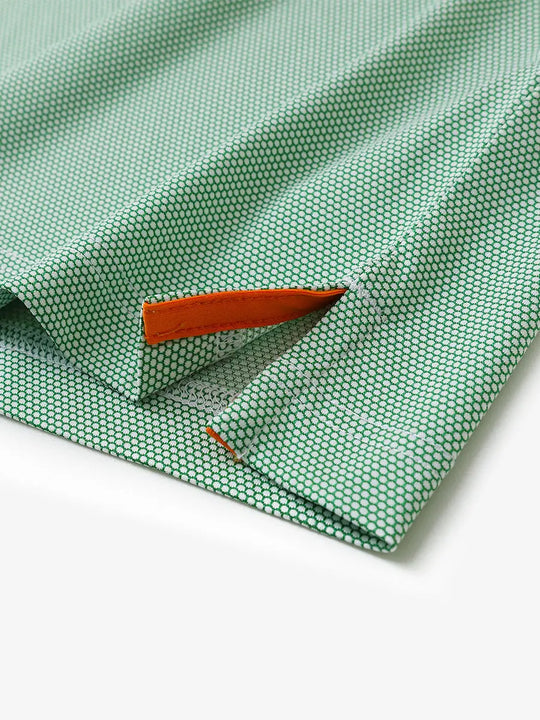 Close-up detail of side hem slit on EMERALD Performance Ananas Jacquard Polo