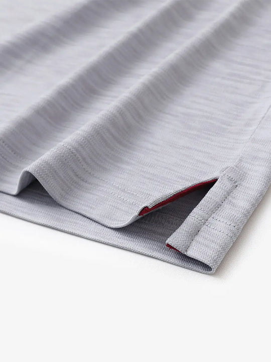 Hem slit detail close-up in FADED DENIM HEATHER Cool Heather Texture Polo