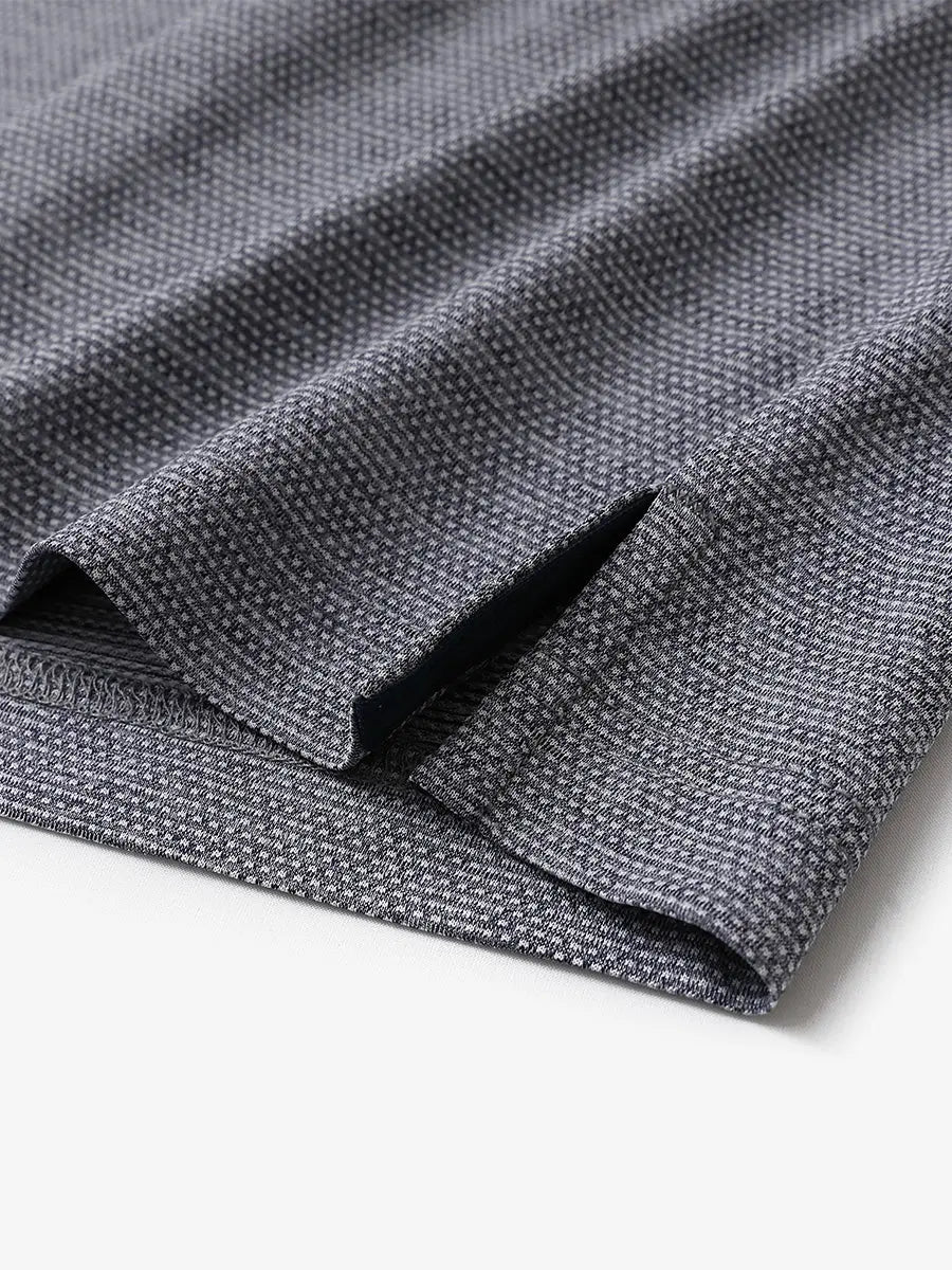 Close-up of side hem slit on Ventilated Heather Jacquard Polo in NAVY HEATHER, showing detail
