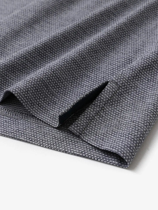 Close-up of side hem slit on Ventilated Heather Jacquard Polo in NAVY HEATHER, showing detail