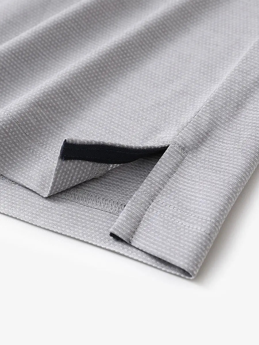 Close-up of side hem slit on Ventilated Heather Jacquard Polo in FADED DENIM HEATHER, showing detail