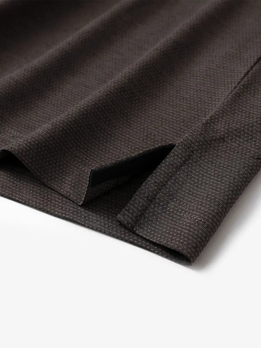 Close-up of side hem slit on Ventilated Heather Jacquard Polo in DARK BROWN HEATHER, showing detail