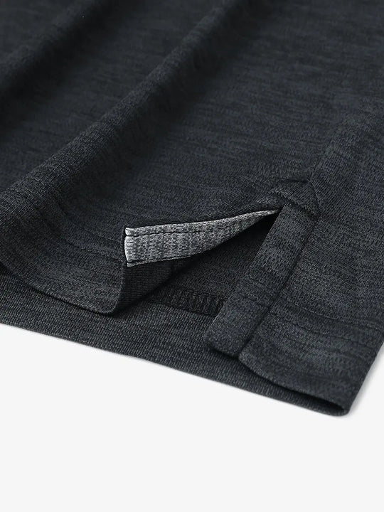 Close-up of hem opening on Modern Fit Melange Polo in BLACK HEATHER, showcasing fine stitching and design.