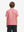 Back half-body view of youth wearing candy pink line performance print boys golf polo, showing rear design